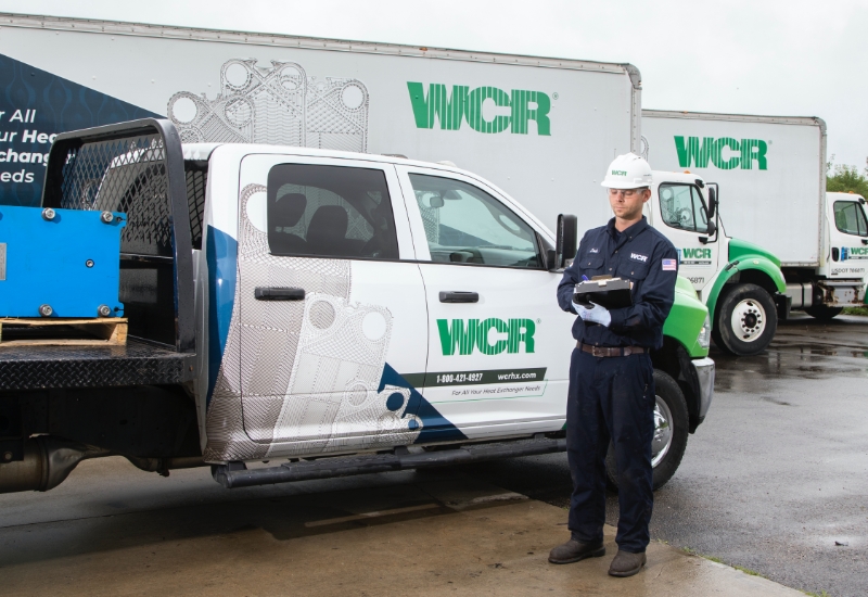 WCR service echnician stands beside WCR trucks